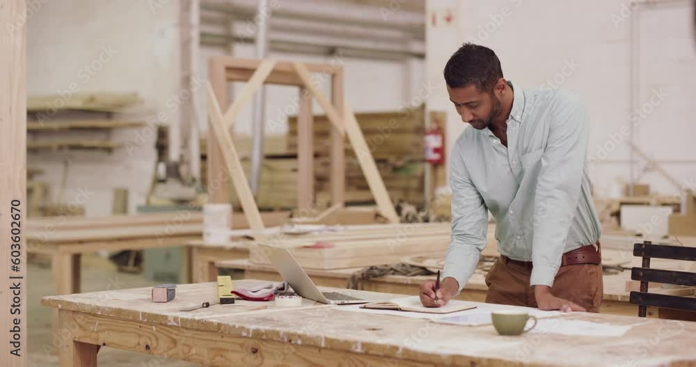 Carpentry, laptop and a business man writing in his factory for planning or professional woodwork. Notebook, design and expertise with a male carpenter or designer working in his creative workshop Carpentry, laptop and a business man writing in his factory for planning or professional woodwork. Notebook, design and expertise with a male carpenter or designer working in his creative workshop