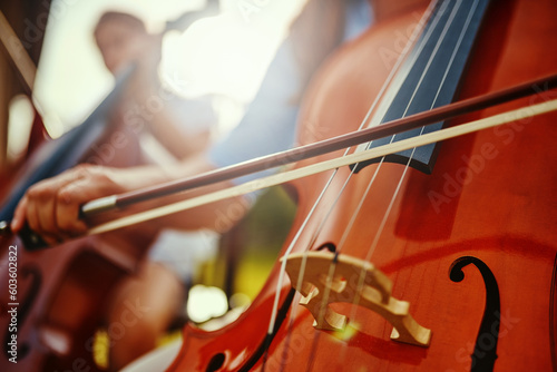 Foto Woman, hand and cello closeup with instrument string and band outdoor playing classical music