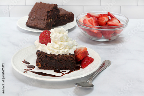 Chocolate Fudge Brownie with fresh strawberries and whipped cream.