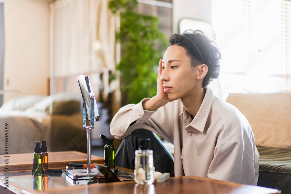 Φωτογραφία Z世代の日本人男性が朝自宅リビングでスキンケアをしている