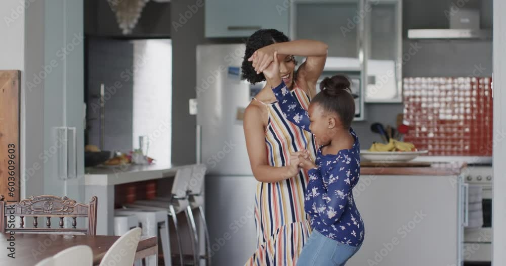 Happy african american mother and daughter dancing in kitchen, slow motion Happy african american mother and daughter dancing in kitchen, slow motion