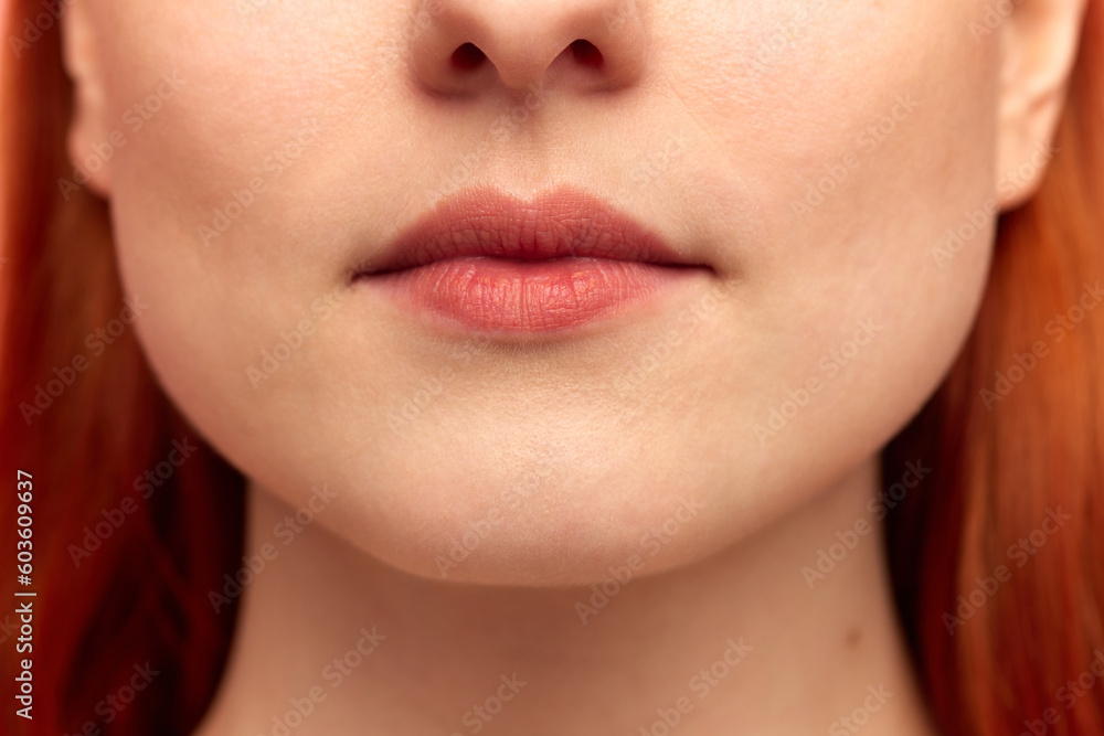 Cropped portrait with lower face of pretty young girl with red hair and natural lips. Close up image. Model with well-kept, perfect skin Cropped portrait with lower face of pretty young girl with red hair and natural lips. Close up image. Model with well-kept, perfect skin