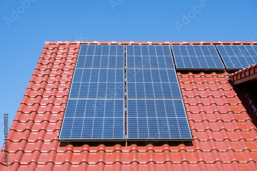 solar panels on a red tiled roof, blue sky, no clouds, sunny day