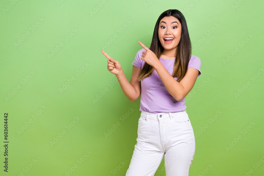 Photo of charming young japanese girl pointing fingers empty space presentation price list restaurant isolated on green color background Photo of charming young japanese girl pointing fingers empty space presentation price list restaurant isolated on green color background