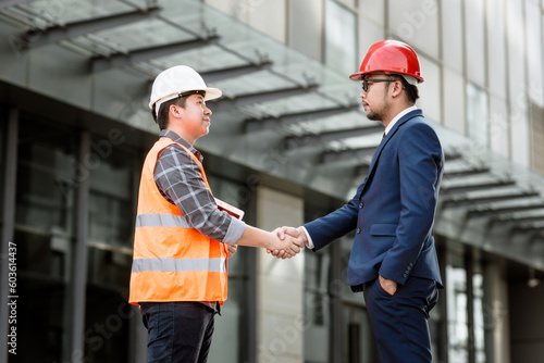 Engineer construction shaking hand with Project manager while working teamwork and cooperation concept after finish agreement construction site, Success collaboration concept.