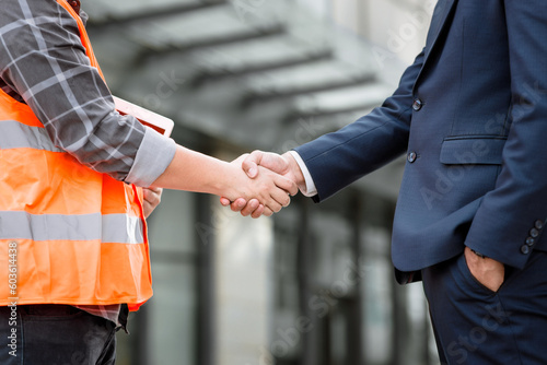 Engineer construction shaking hand with Project manager while working teamwork and cooperation concept after finish agreement construction site, Success collaboration concept.