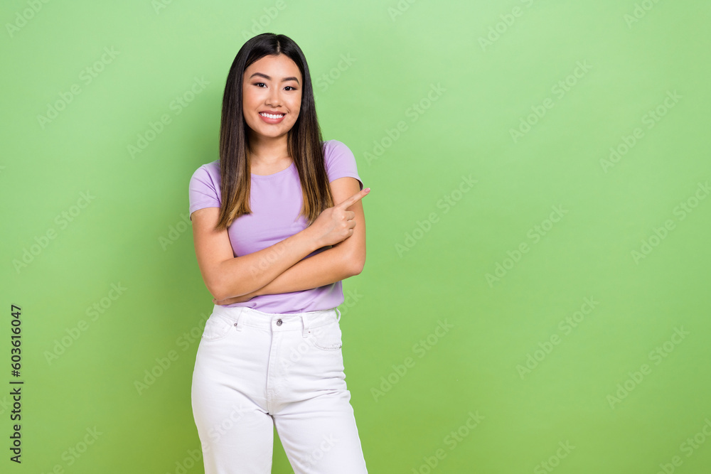 Photo of attractive japanese korean young woman finger point empty space wear trendy purple clothes isolated on green color background Photo of attractive japanese korean young woman finger point empty space wear trendy purple clothes isolated on green color background