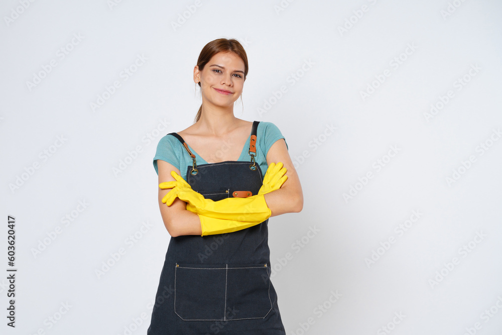 Young woman wearing yellow rubber gloves standing with arm crossed isolated over white background. Young woman wearing yellow rubber gloves standing with arm crossed isolated over white background.