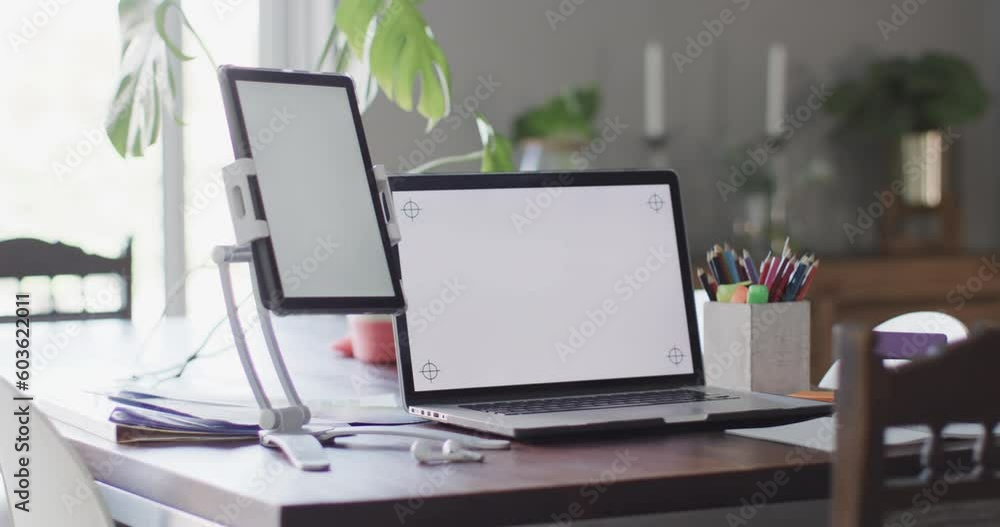 Empty house room with laptop and tablet with copy space on screens on table in slow motion Empty house room with laptop and tablet with copy space on screens on table in slow motion