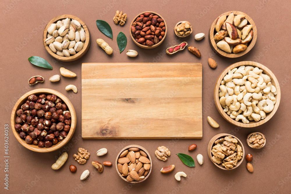 mixed nuts in wooden bowl. Mix of various nuts on colored background. pistachios, cashews, walnuts, hazelnuts, peanuts and brazil nuts mixed nuts in wooden bowl. Mix of various nuts on colored background. pistachios, cashews, walnuts, hazelnuts, peanuts and brazil nuts
