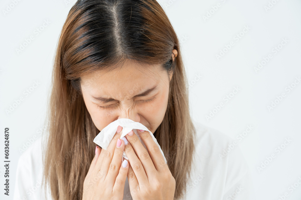 Pollen Allergies, asian young woman sneezing in a handkerchief or blowing in a wipe, allergic to wild spring flowers or blossoms during spring. allergic reaction, respiratory system problems Pollen Allergies, asian young woman sneezing in a handkerchief or blowing in a wipe, allergic to wild spring flowers or blossoms during spring. allergic reaction, respiratory system problems