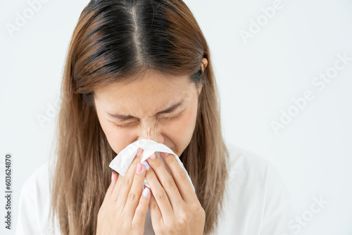 Pollen Allergies, asian young woman sneezing in a handkerchief or blowing in a wipe, allergic to wild spring flowers or blossoms during spring. allergic reaction, respiratory system problems