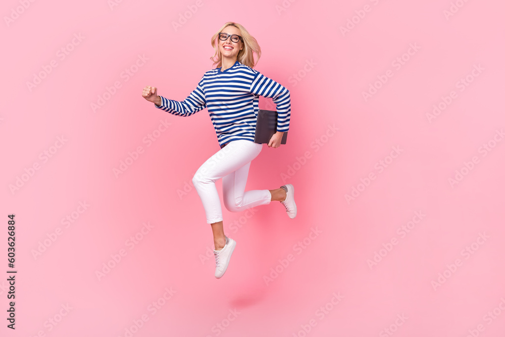 Full length photo of cute purposeful lady wear striped shirt spectacles jumping holding gadget isolated pink color background