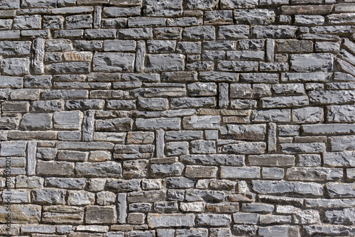 Old rough gray brick stone wall