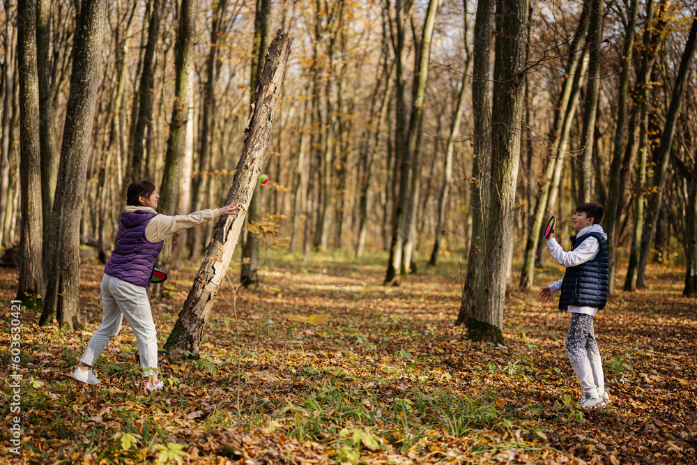 Mother with son play in autumn forest catch and toss ball game. Mother with son play in autumn forest catch and toss ball game.