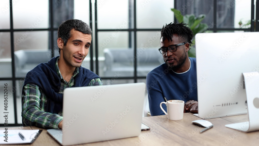 Smiling beautiful businesspeople working on laptop in modern office lobby Smiling beautiful businesspeople working on laptop in modern office lobby