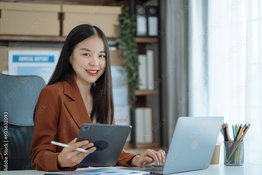 Female asian sitting at the desk, looking to camera. Female asian sitting at the desk, looking to camera.