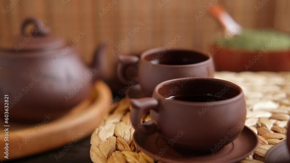Tea Ceremony. Traditional Asian Tea Utensil, Serving Authentic Set. Person Pouring Tea from Brown Pottery Teapot to Teacup. Bamboo Tray. Lifestyle. Wellness Balance Health. Tea Brewing Equipment Tea Ceremony. Traditional Asian Tea Utensil, Serving Authentic Set. Person Pouring Tea from Brown Pottery Teapot to Teacup. Bamboo Tray. Lifestyle. Wellness Balance Health. Tea Brewing Equipment