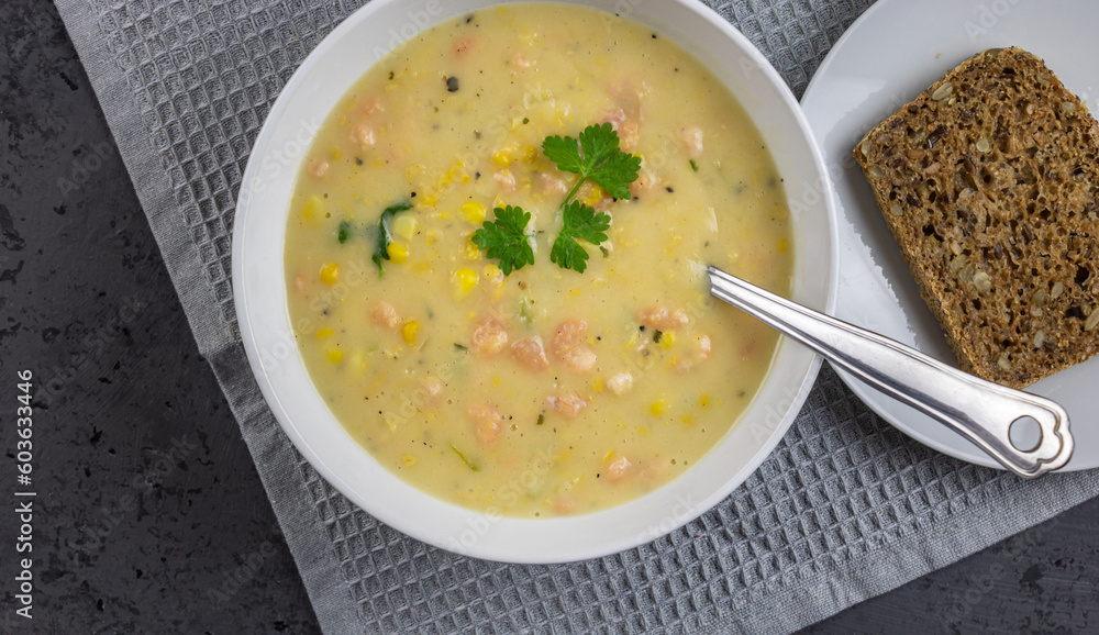 Shrimp and corn chowder with bread - top view with copy space