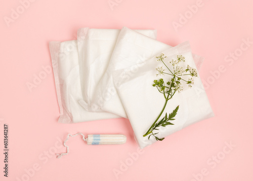 Sanitary pads and tampon on a pink background. © Olena