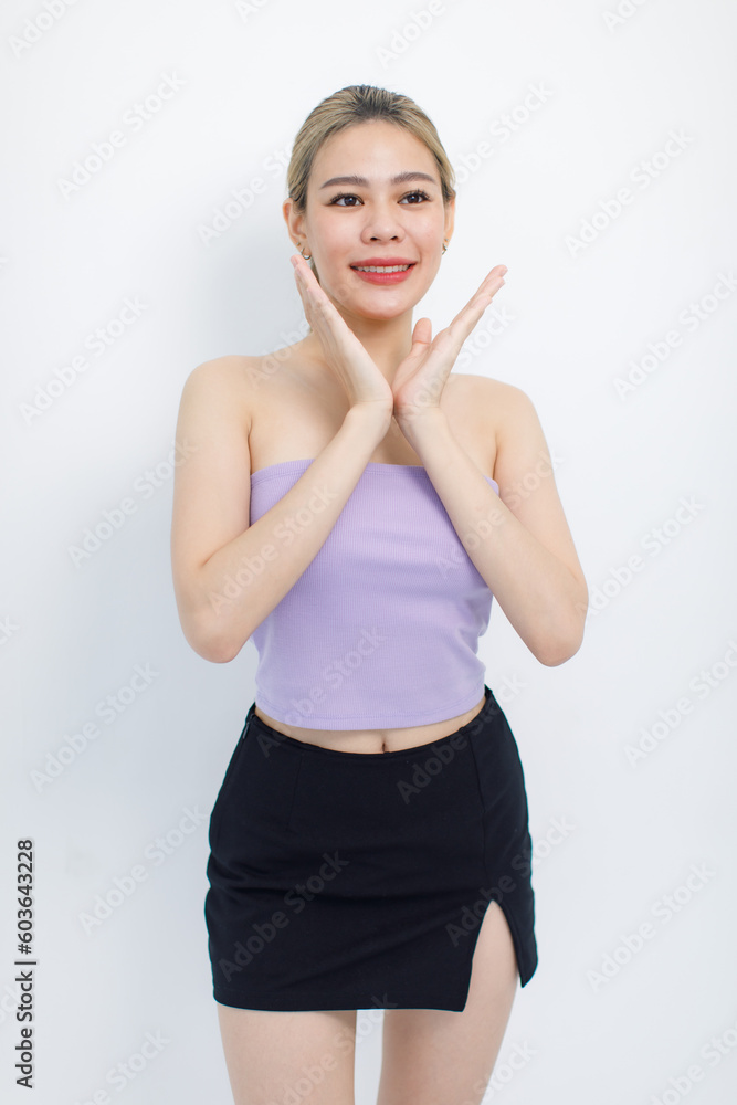 Portrait isolated cutout studio shot of Asian beautiful pretty cheerful female model in tube cropped top shirt standing smiling using hands massaging cream oil moisturizer on face on white background Portrait isolated cutout studio shot of Asian beautiful pretty cheerful female model in tube cropped top shirt standing smiling using hands massaging cream oil moisturizer on face on white background