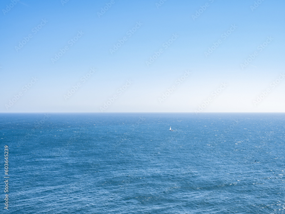 Ozean mit blauem Himmel und Segelboot Ozean mit blauem Himmel und Segelboot