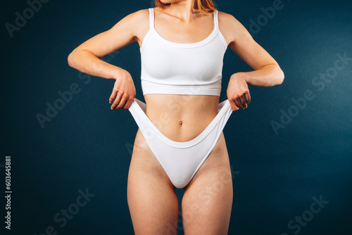 a girl in the studio pulling her white panties.