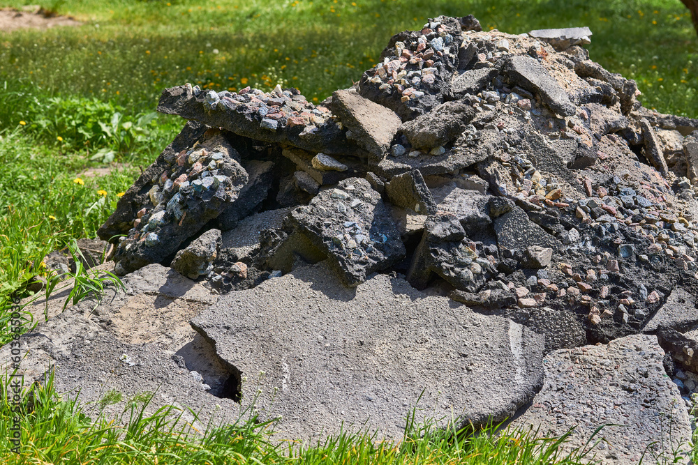 A pile of old broken asphalt with rubble left after the repair of the road 