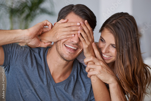 Covering eyes, couple and happy surprise in living room or woman with partner, hands cover face and hide reveal. Girlfriend, man and love or playing together, guess who or excited announcement