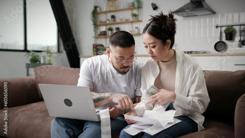 Asian Couple Accounting Domestic Finances. Young family managing bills and taxes together. Married couple counts money paying bills.
