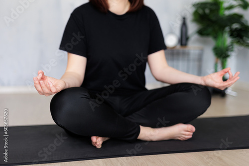 yoga and meditation concept - close up of woman doing yoga sitting on yoga mat