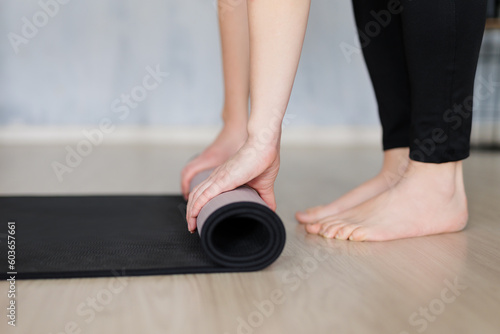 close up of barefoot woman preparing a yoga mat for training at home