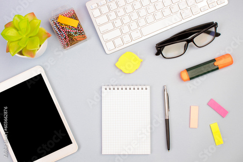 Tablet, calculator, phone, pen and a cup of coffee, lot of things on a light background. Top view with copy space.