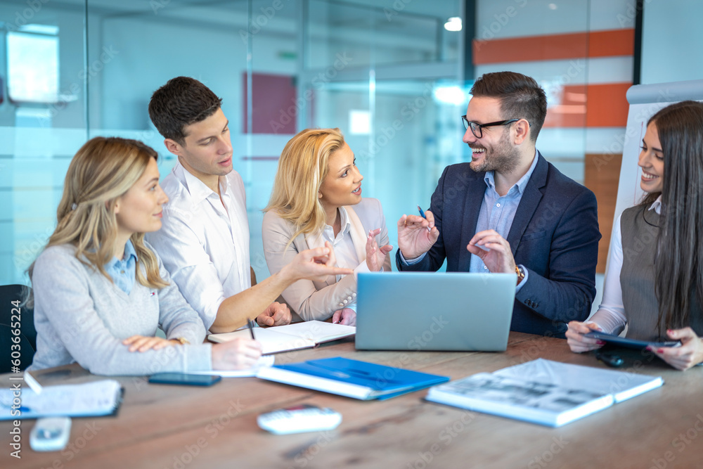 Group of business people gathered together at a table working on project starting from idea to implementation. Group of business people gathered together at a table working on project starting from idea to implementation.
