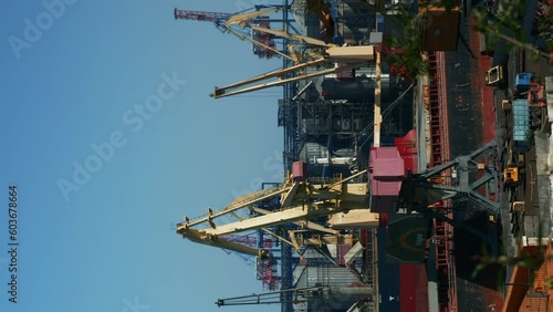 Sea cargo port and container terminal. Ships loading by cranes. Vertical video photo
