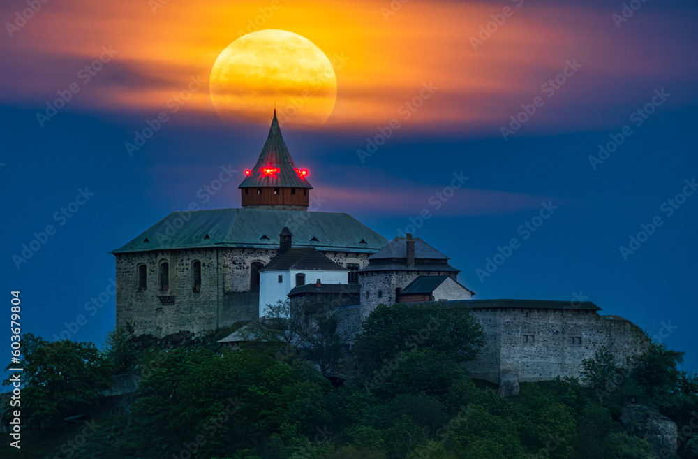 Full moon rising above the Kuneticka hora castle in Czechia.