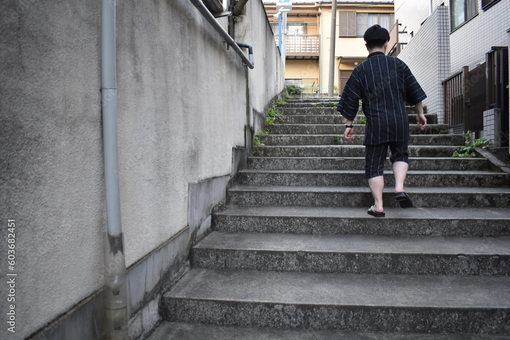 下駄で階段を登る甚平を着た男性 下駄で階段を登る甚平を着た男性