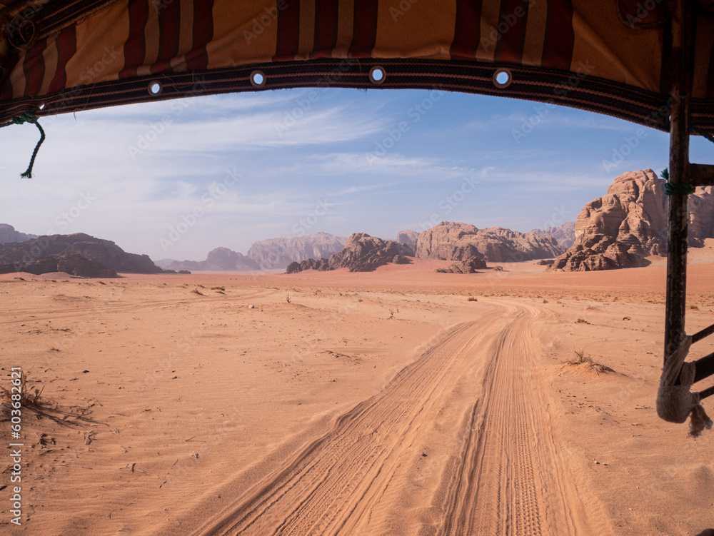 View of tire tracks in the sand of the Wadi Rum desert from the back of a Jeep. View of tire tracks in the sand of the Wadi Rum desert from the back of a Jeep.