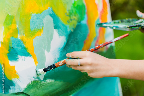 Artist with brush beginning an acrylic painting on canvase photo