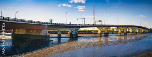 Essex Bridge over the Danvers River at low tide, next to Remond Park in Salem, Massachusetts, a panoramic landscape at sunrise