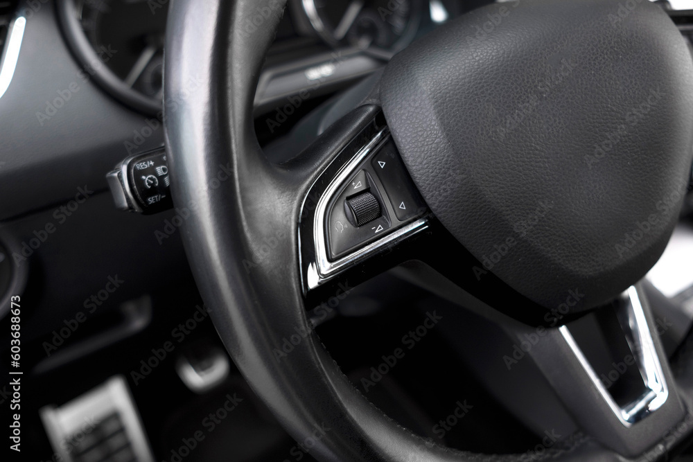 Modern black car interior, leather steering wheel.  Details interior. 