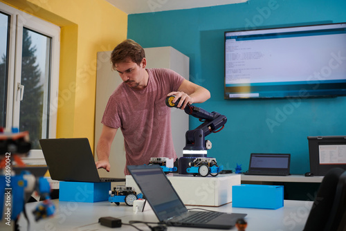 Obraz na plátně A student testing his new invention of a robotic arm in the laboratory, showcasing the culmination of his research and technological prowess