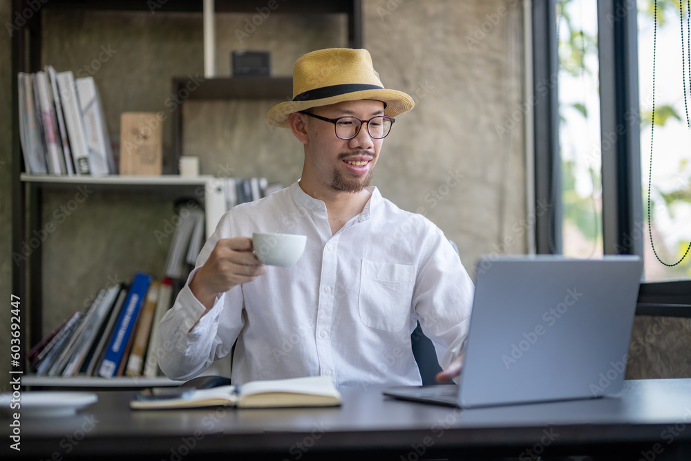 Businessman in eyeglasses enjoying coffee while working.with laptop at his office. Businessman in eyeglasses enjoying coffee while working.with laptop at his office.