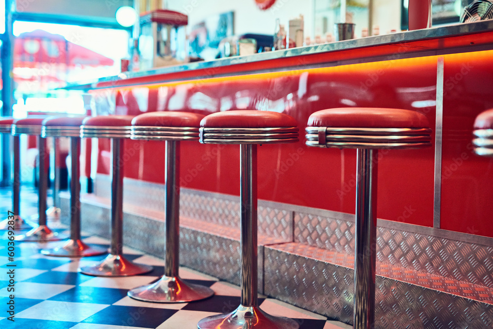 Trendy, vintage and retro interior in a diner, restaurant or cafeteria with funky decor. Booth, old school and chairs by a counter or bar in a groovy, vibrant and stylish old fashioned empty cafe. - obrazy, fototapety, plakaty 