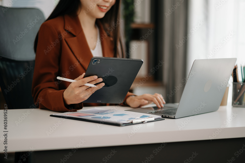 Business woman sitting front tablet ,laptop computer with financial graphs and statistics on monitor. Business woman sitting front tablet ,laptop computer with financial graphs and statistics on monitor.
