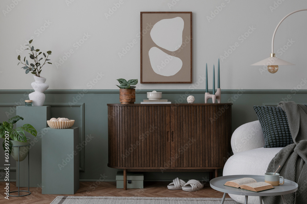 Warm and cozy composition of spring living room interior with mock up poster frame, wooden sideboard, white sofa, green stand, base with leaves, plants, stylish lamp. Home decor. Template. - obrazy, fototapety, plakaty 