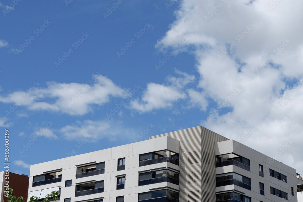 Fragment of modern residential condo buildings exterior. Copy space. Blue sky with vibrant clouds
