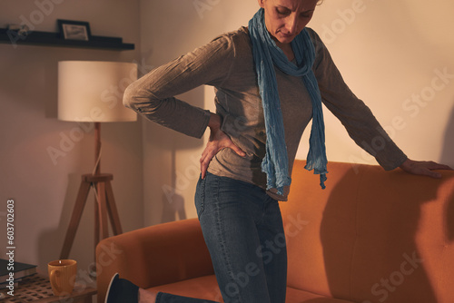 Fotografiet Woman with hip and back pain at home.