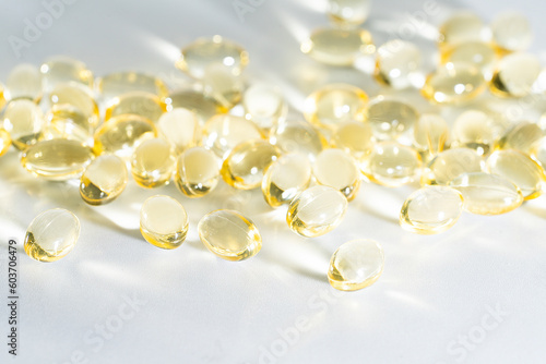 Vitamin D yellow supplement gel capsules, Fish Oil Omega 3 on white background, macro shot 