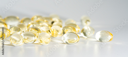 Vitamin D yellow supplement gel capsules, Fish Oil Omega 3 on white background, macro shot 